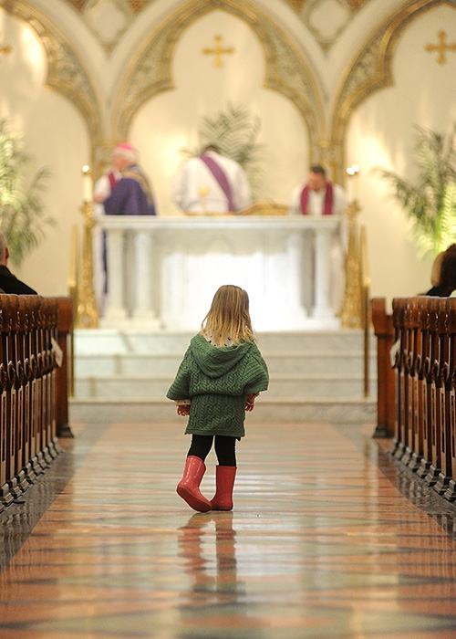 A child dressed in Irish green looks out on the Alter at St. Joseph Cathedral during the St. Patrick's Day Mass. (Dan Cappellazzo/Staff Photographer)
